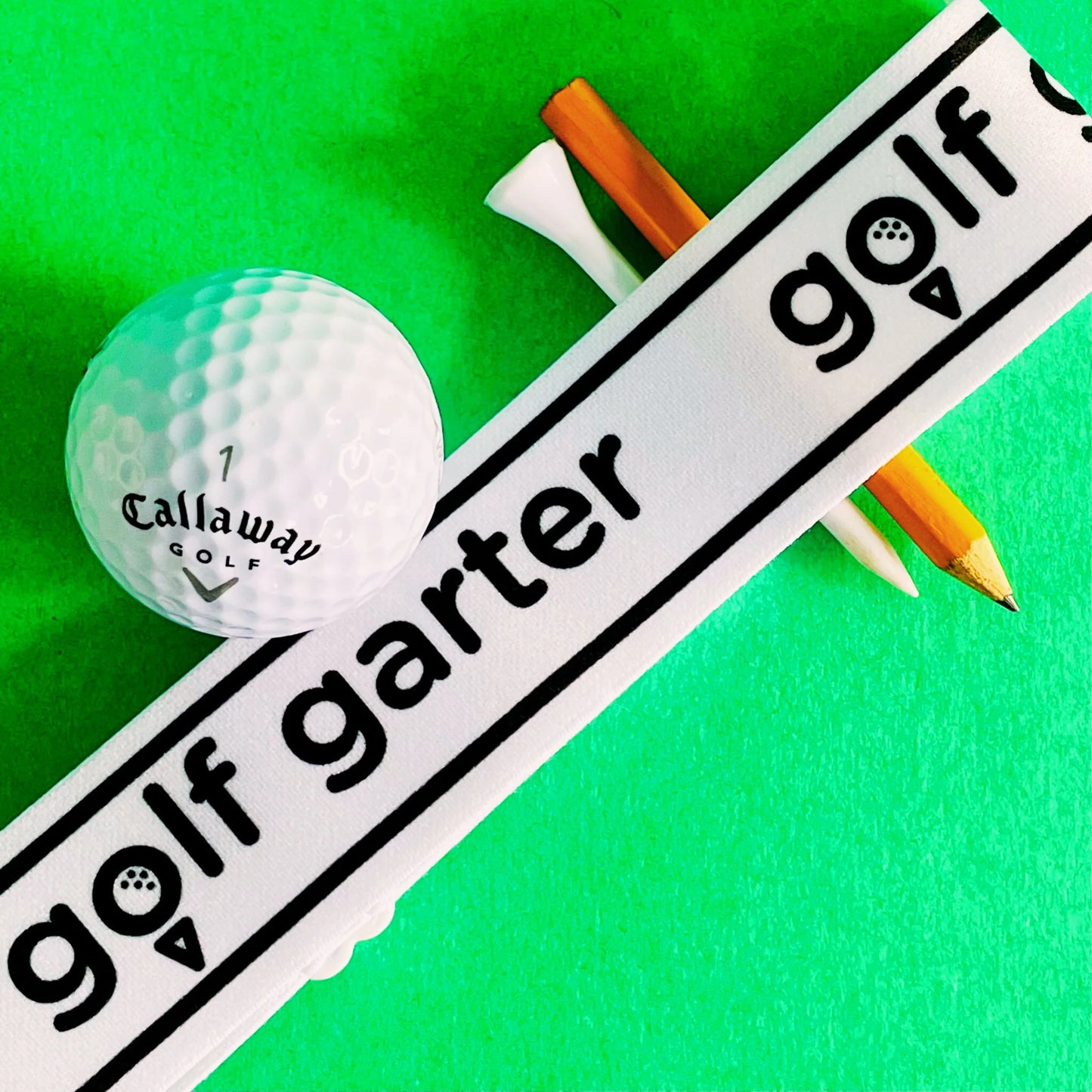 Golf garter with a golf ball, tee and pencil.